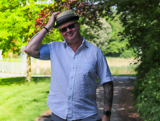 Man With Hat, Sunglasses And Tattoss In The Park