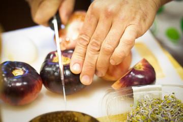hand and knife cutting a tomato 