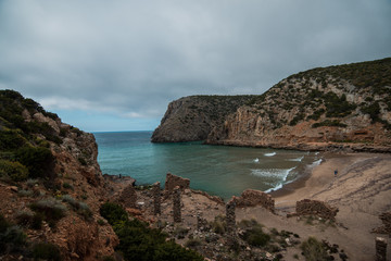 wild beach in sardinia, italy with clear blue sea and rocks