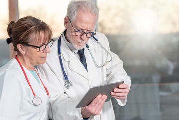 Fototapeta premium Two doctors discussing about medical report on tablet