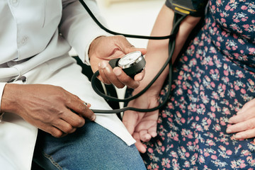 A senior woman visiting a therapist at the clinic for checking her health. Lifestyle portrait at the cabinet. Measuring blood pressure and heart beating. Concept of medicine, healthcare and prevention