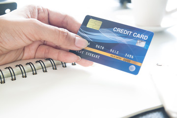 Hand holding plastic credit card. E-payment, technology and online shopping concept