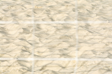 View of the sand on the beach through the protective grid