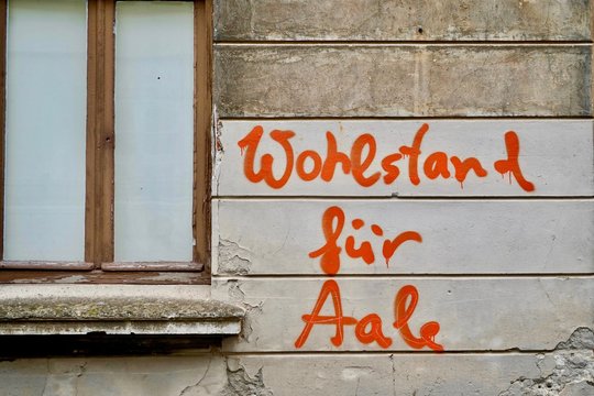 "Wohlstand für Aale", Spruch an Hauswand in Wismar