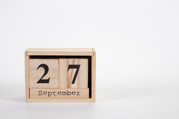 Wooden calendar September 27 on a white background