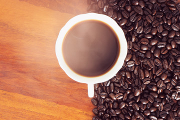 cup of coffee with beans on white background