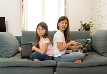 Obraz premium Two pretty sisters having fun together playing and surfing on th