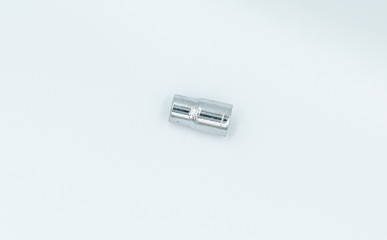 This capture of a silver socket wrench on a white background and in a studio light 