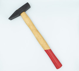 This is capture of a red and beige hammer on a white background and in a studio light 