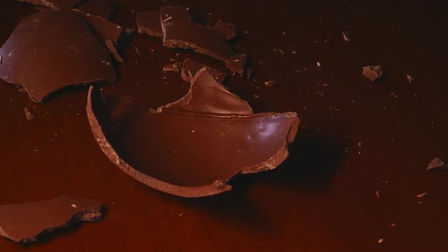 An Easter egg has been opened, the broken chocolate shell is on the table 