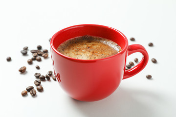 Cup of coffee with frothy foam and coffee beans on white background, space for text and closeup. Coffee time accessories