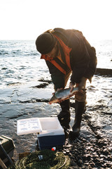 Close up of a fisherman putting caught fish