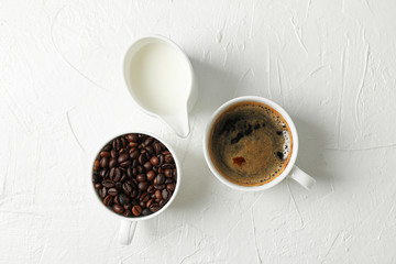 Fresh coffee, milk and coffee beans on white background, space for text and top view. Breakfast composition