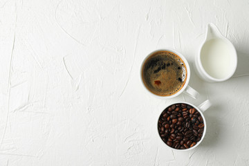 Fresh coffee, milk and coffee beans on white background, space for text and top view. Breakfast composition