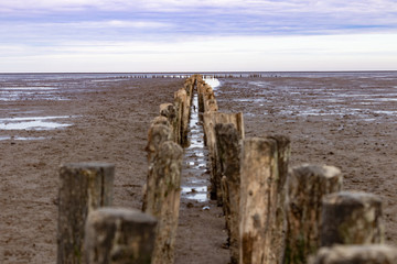 Old wooden pier reaching in the mudflats at the north sea in germany