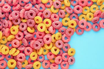 Colorful cereal rings corn flakes on blue background with copy space. Flay lay overhead view