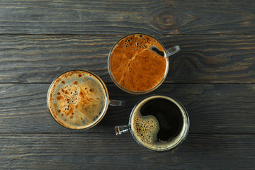 Cups of coffee on wooden background, space for text and top view
