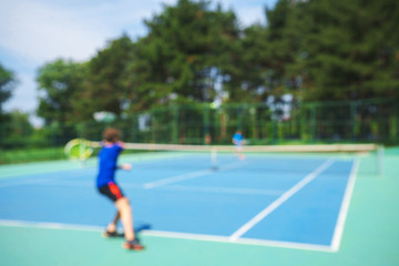 Fototapeta na wymiar Teenager boy playing tennis on court. Sport summer concept. Blurred background.