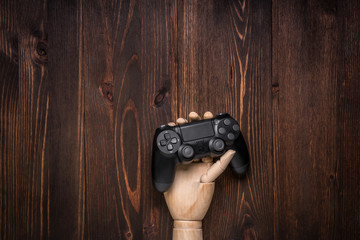 Modern black gamepad on a dark wooden background. Game concept with copy space for text.