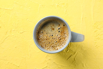 Cup of coffee with frothy foam on color background, top view and space for text. Coffee time...