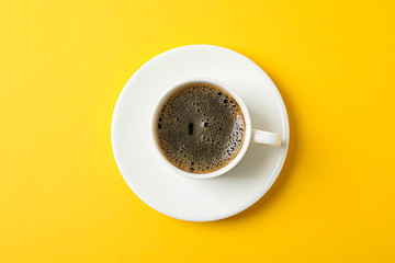 Cup of coffee with frothy foam on color background, space for text and top view. Coffee time accessories
