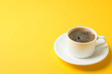 Cup of coffee with frothy foam on color background, space for text. Coffee time accessories