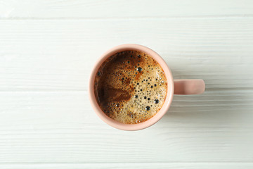 Cup of coffee with frothy foam on wooden background, space for text and top view. Coffee time accessories