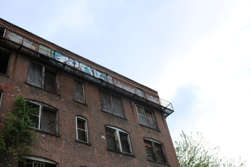 Old abandoned condemned brick building with broken boarded up glass windows