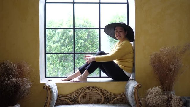 Asian senior woman miss good memory looking at picture in Tuscan style house