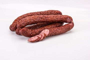 Thin smoked sausage on a white background.