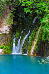 small waterfall among green stones