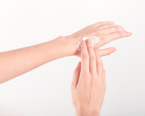 Spa treatment. Close Up of female hands applying hand cream. Woman holding cream tube and applying moisturizer cream on her beautiful hands for clean and soft skin.