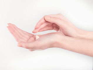 Spa treatment. Close Up of female hands applying hand cream. Woman holding cream tube and applying moisturizer cream on her beautiful hands for clean and soft skin.