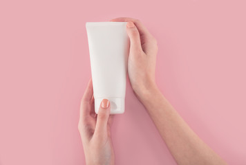 Spa treatment. Close Up of female hands applying hand cream. Woman holding cream tube and applying moisturizer cream on her beautiful hands for clean and soft skin.