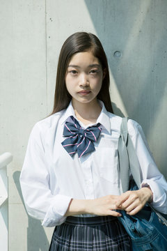 屋外に立つカメラ目線の女子高校生