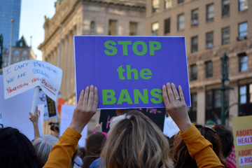 People holding signs in New York City protesting abortion bans that have swept across parts of the...