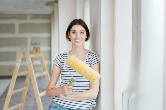 Young woman holding a paint roller
