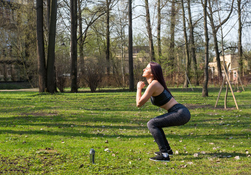 girl doing outdoor squats in the Park