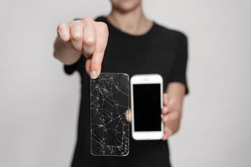 Woman hands holding broken screen protection and saved smartphone