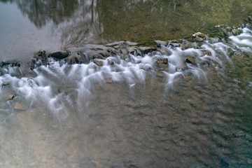 Wasser fließt über Steine in einem Fluss