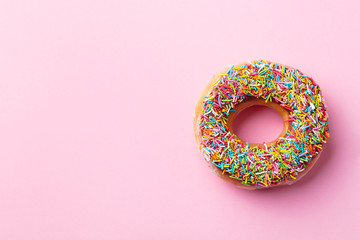 Donut on pink background. Top view. Copy space.