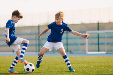 Two Junior Soccer Players Training with Soccer Ball on Stadium Grass Pitch
