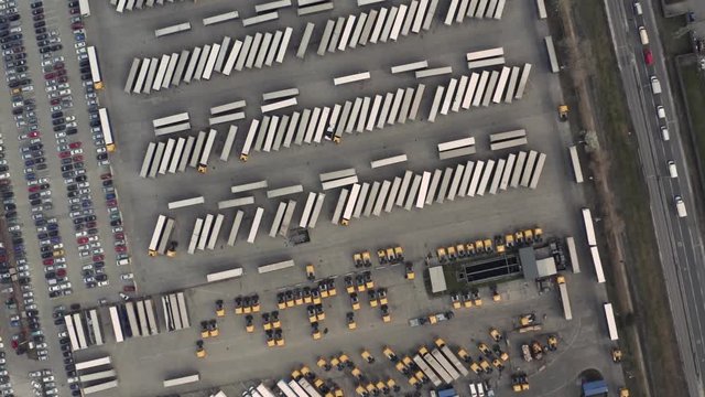 Line of trucks and trailers from above at a cargo terminal