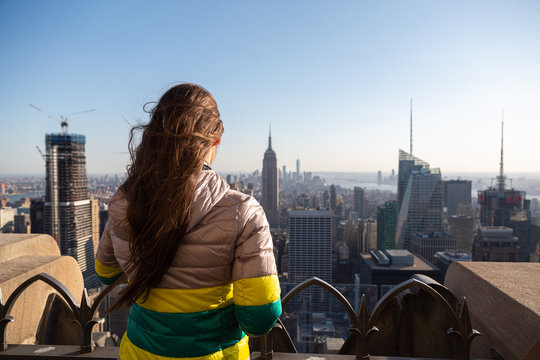 Tourist enjoying view of New York City cityscape. Young woman looking at Manhattan panorama