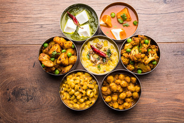 assorted Indian/Pakistani food in stainless steel bowls creating pattern or design, selective focus