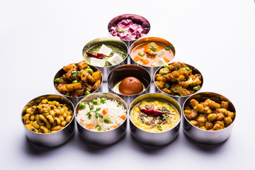 assorted Indian/Pakistani food in stainless steel bowls creating pattern or design, selective focus