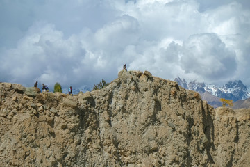 Low angle view of the cliff near the Hopper glacier in Nagar valley with snow capped mountains in karakoram range in the background. Gilgit Baltistan, Pakistan.