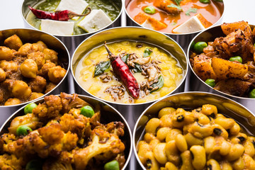 assorted Indian/Pakistani food in stainless steel bowls creating pattern or design, selective focus