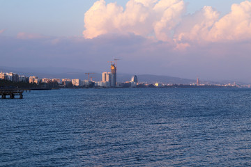 Beautiful Coastline of Limassol at sunset. Perfect coast of Lemesos with many high-rise buildings. Cloudy sky with red and pink colour from setting sun. Second biggest city in Cyprus