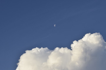 Céu azul, nuvem cumulus e Lua durante o dia